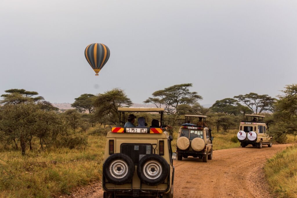 Scenic safari adventure in Tarangire with off-road vehicles and a hot air balloon in the savannah.