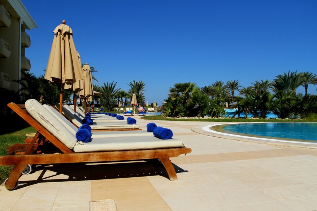 Best Time to Visit Kenya for Safari in 2026 – Complete Travel Guide Scenic view of luxurious poolside loungers at a tropical resort under clear blue sky.