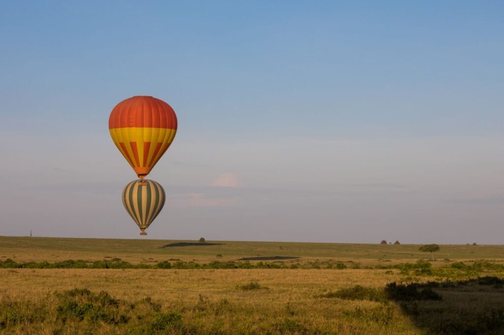 Maasai Mara Safari Guide: Everything You Need to Know Before You Go Hot air balloons floating over the Maasai Mara savannah during sunrise in Kenya.