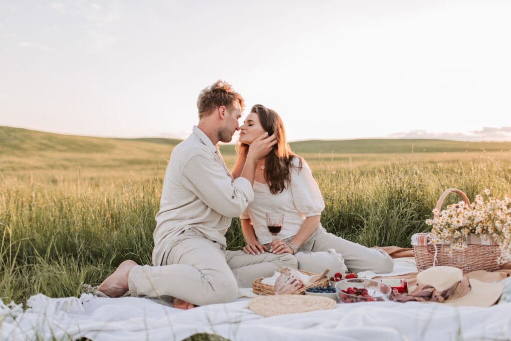 Home A couple enjoying a romantic picnic at sunset, surrounded by nature.