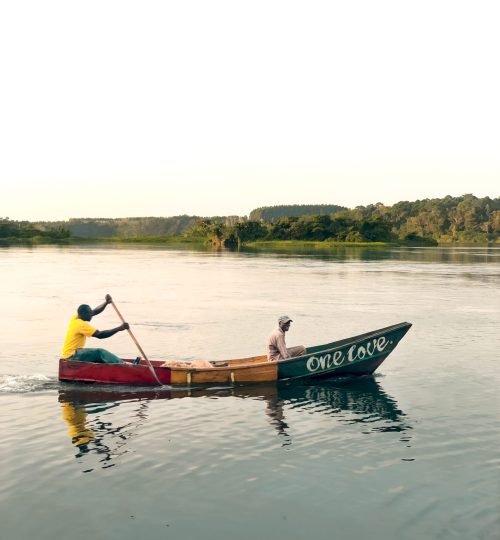 A peaceful scene of two men paddling a boat labeled 'One Love' on a calm Ugandan river.